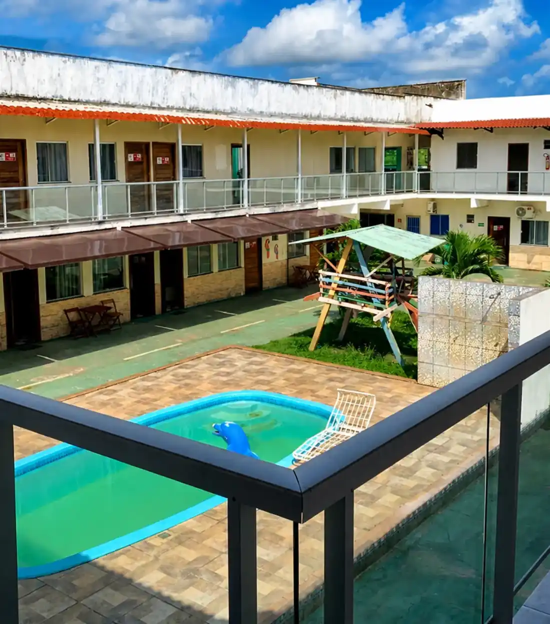 Vista da piscina e do pátio a partir da varanda de um quarto