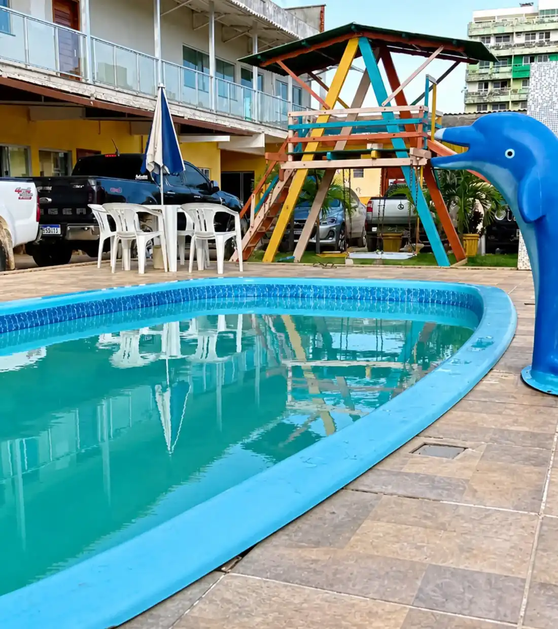 Piscina ao ar livre e terraço com piso de cerâmica e brinquedos